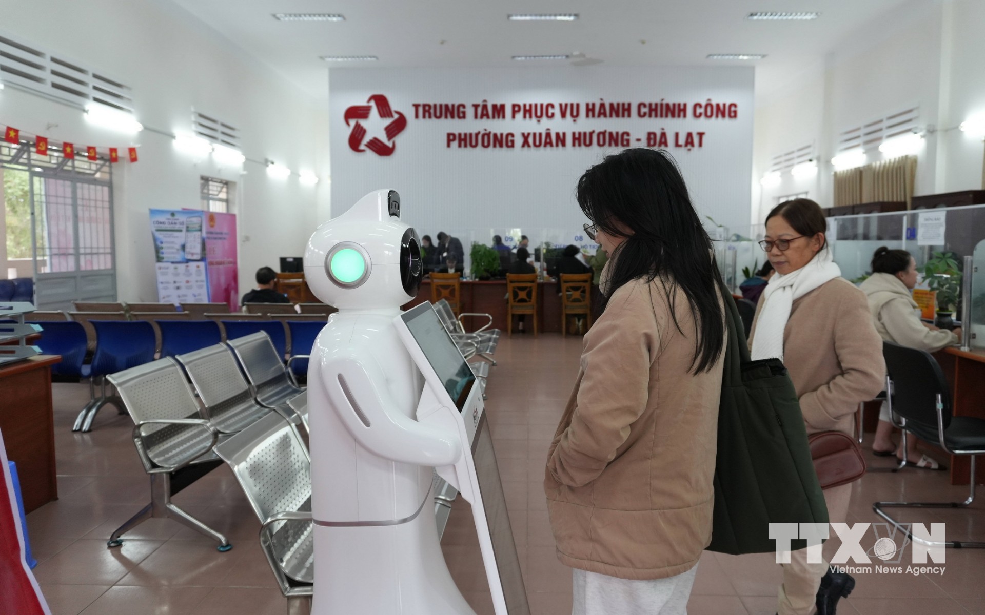 Người dân phường Xuân Hương – Đà Lạt nhờ robot AI hướng dẫn thủ tục cấp lại giấy chứng nhận đăng ký kinh doanh. (Ảnh: Nguyễn Dũng/TTXVN)